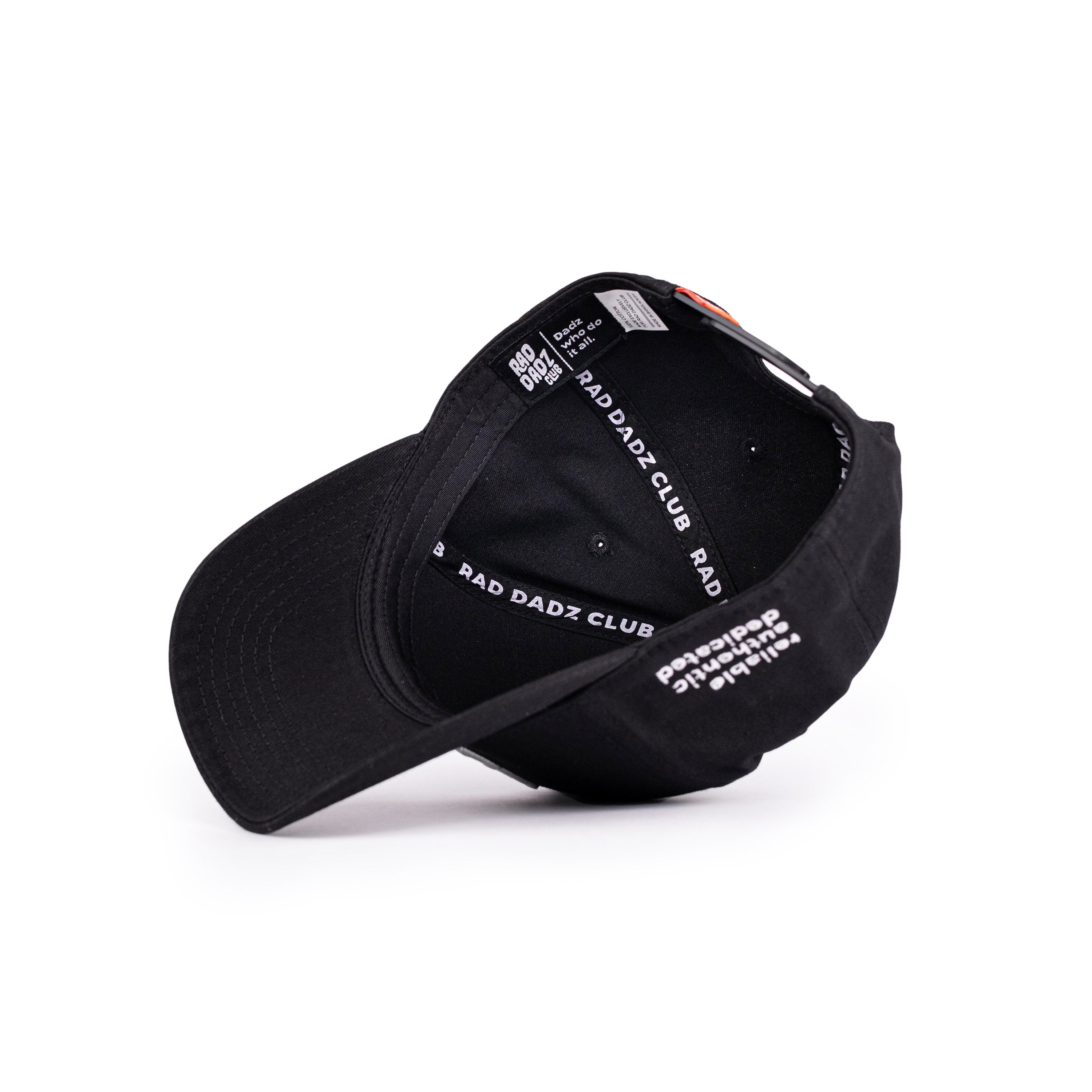 Upside down black baseball cap with white interior details.